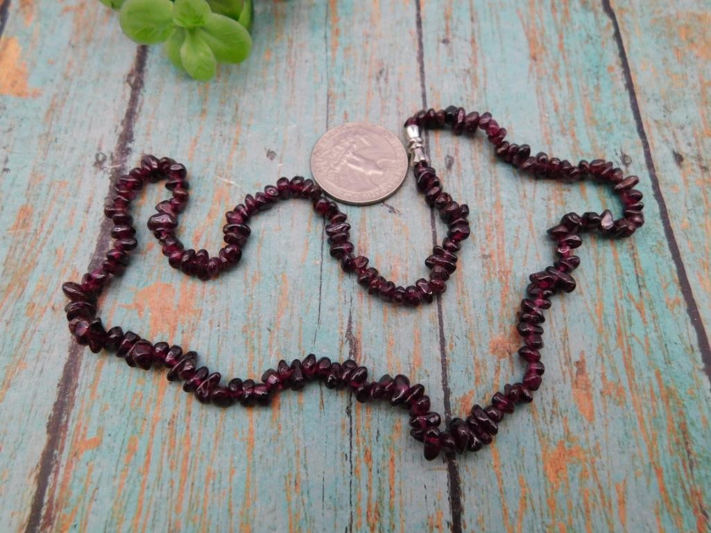 Garnet Chip Bead Necklace: Long strand necklace of deep red garnet chip beads with silver-tone clasp.