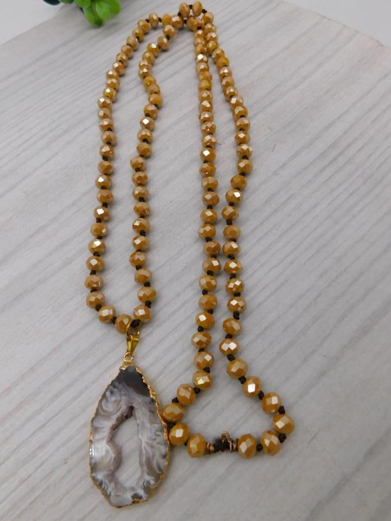 Agate Slice Pendant Beaded Necklace: Long faceted amber-tone bead necklace featuring a banded agate slice pendant in gold-tone bezel.