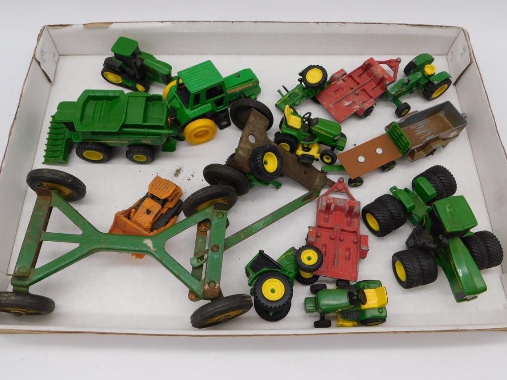 John Deere Die-Cast Farm Toy Tractor & Implement Lot: Large group of green and yellow John Deere die-cast farm toys including tractors, a combine harvester, wagons, a hay rake, and assorted implements. Various scales and conditions typical of played-with