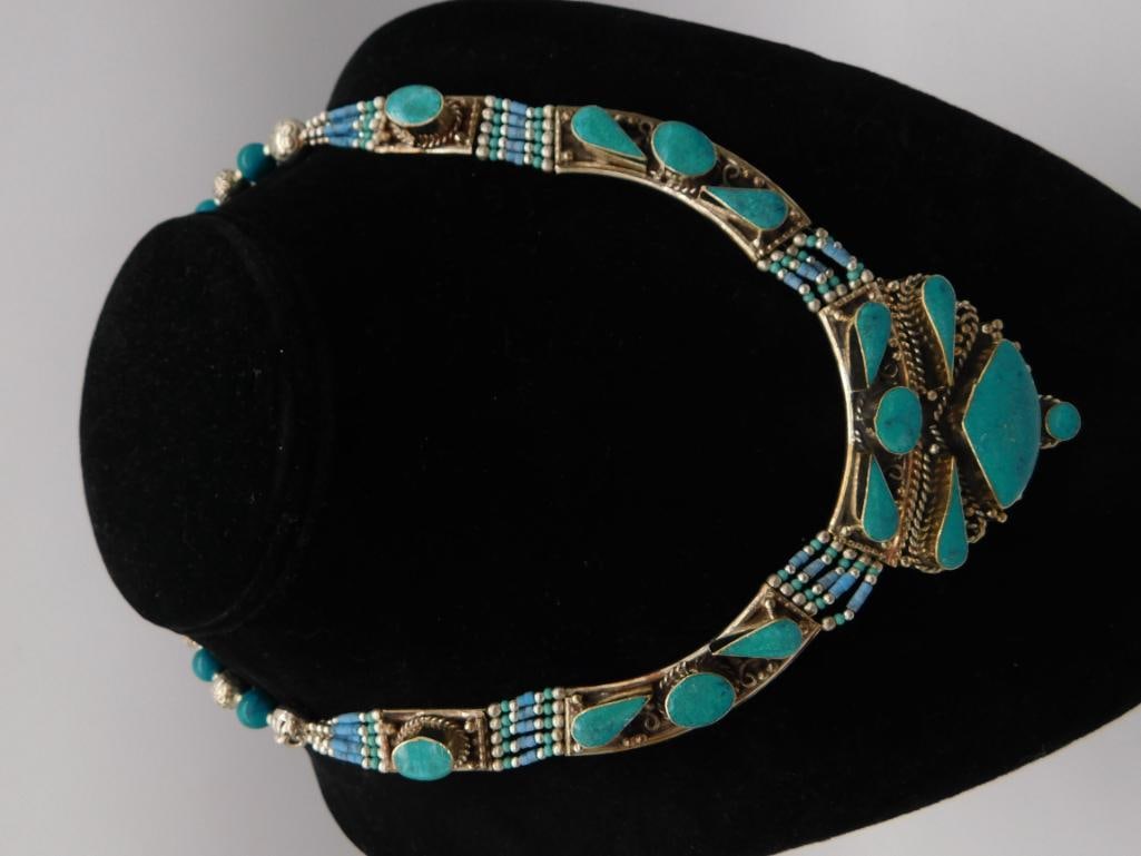 Turquoise and Silver-Tone Statement Necklace, Tibetan Style: Bold ethnic-style necklace featuring an ornate silver-tone filigree pendant and links set with numerous turquoise cabochons and blue seed-bead accents, with turquoise bead spacers along the chain. A m