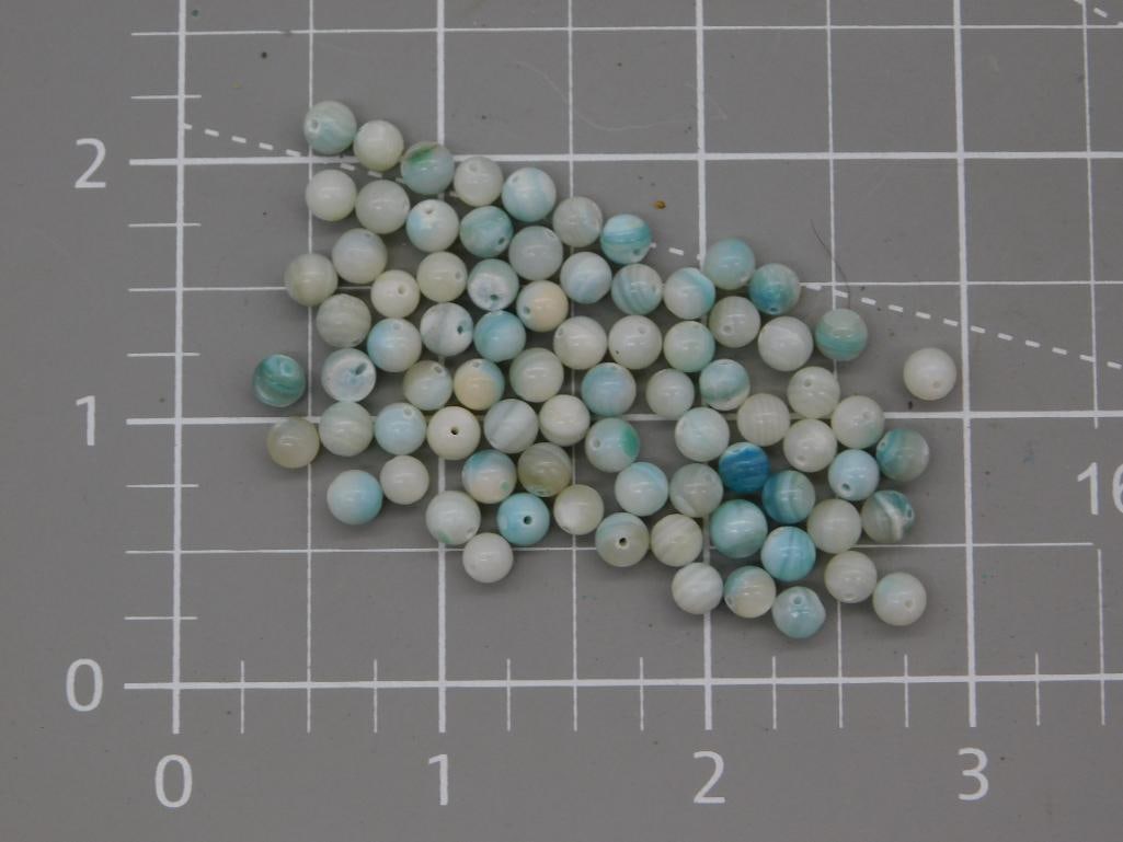 Blue-Banded Gemstone Bead Lot, 15 Grams: A group of small round beads in pale aqua, cream, and banded blue-green tones, likely amazonite or dyed agate, each approximately 6mm in diameter with drilled center holes. Roughly seventy beads are