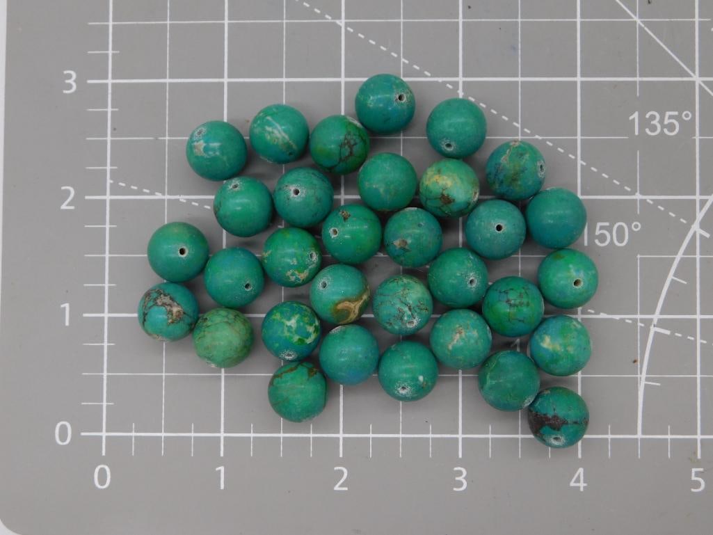 Turquoise Round Bead Lot: Loose strand of round turquoise beads in green-blue tones with natural brown matrix veining. Beads measure approximately 8mm each, shown on a ruled mat. Total weight labeled 87 grams. Part of the