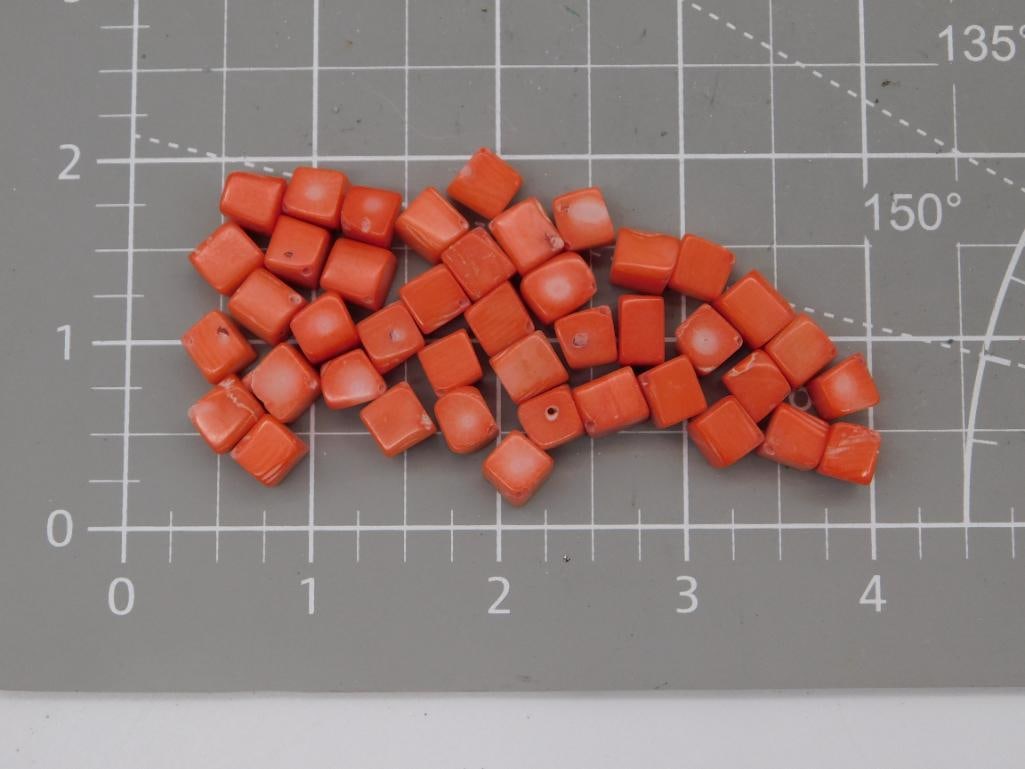 Coral-Style Orange Square Bead Lot: Lot of orange square-cut beads with a coral-like polished finish, each approximately 6-7mm, shown on a ruled mat. Total weight labeled 41 grams. Part of the 2026 Rock Auction.