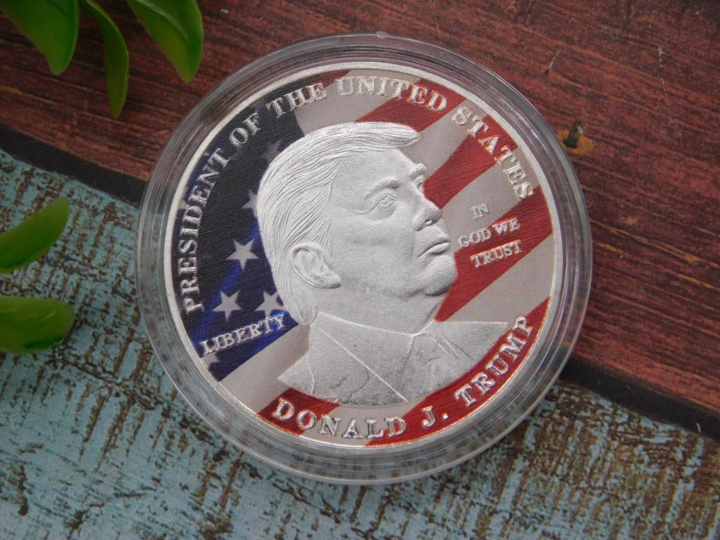 Donald J. Trump Commemorative Silver-Tone Coin, Capsule Encased: A commemorative 'President of the United States, Donald J. Trump' coin in colorized red-white-blue design, reverse showing the American eagle 'United States of America - Make America Great Again' seal