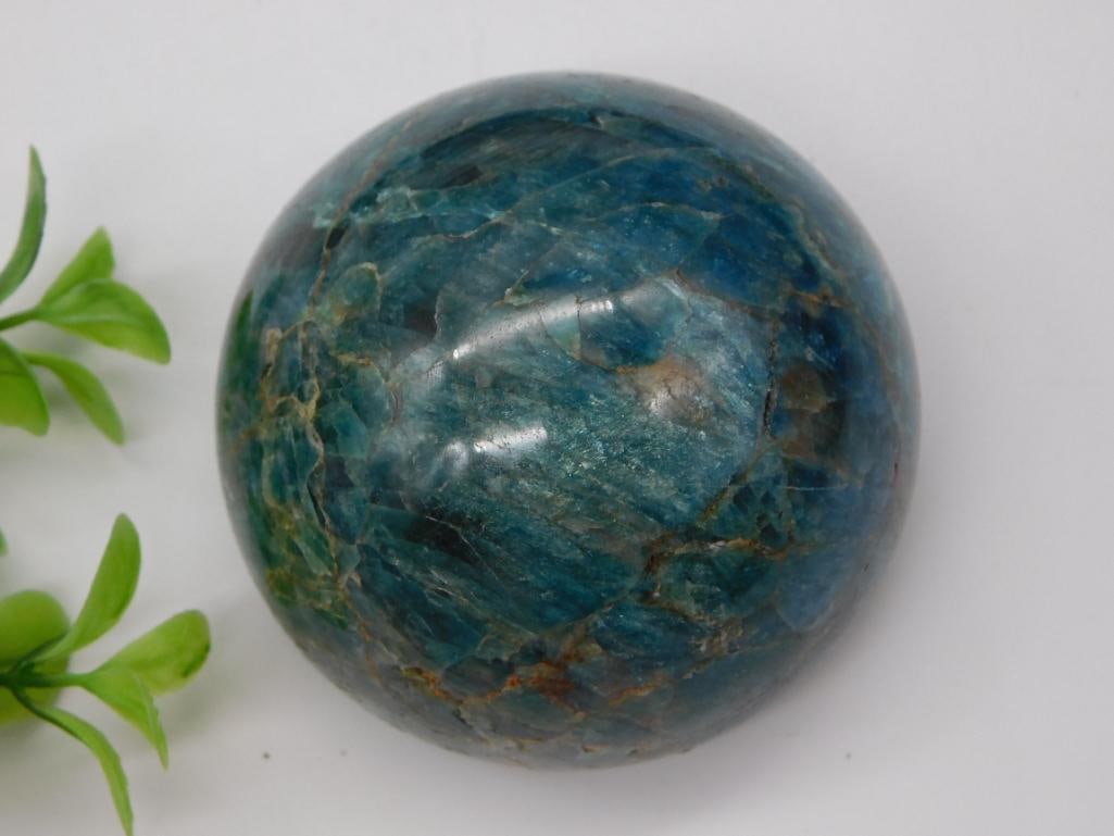 Blue Apatite Sphere - Polished Round Mineral Specimen: A polished round blue apatite sphere with natural mineral veining in teal, gold, and gray tones. Approximately 2.5 inches in diameter, shown with a 1966 Washington quarter and the original 'LOT 713786