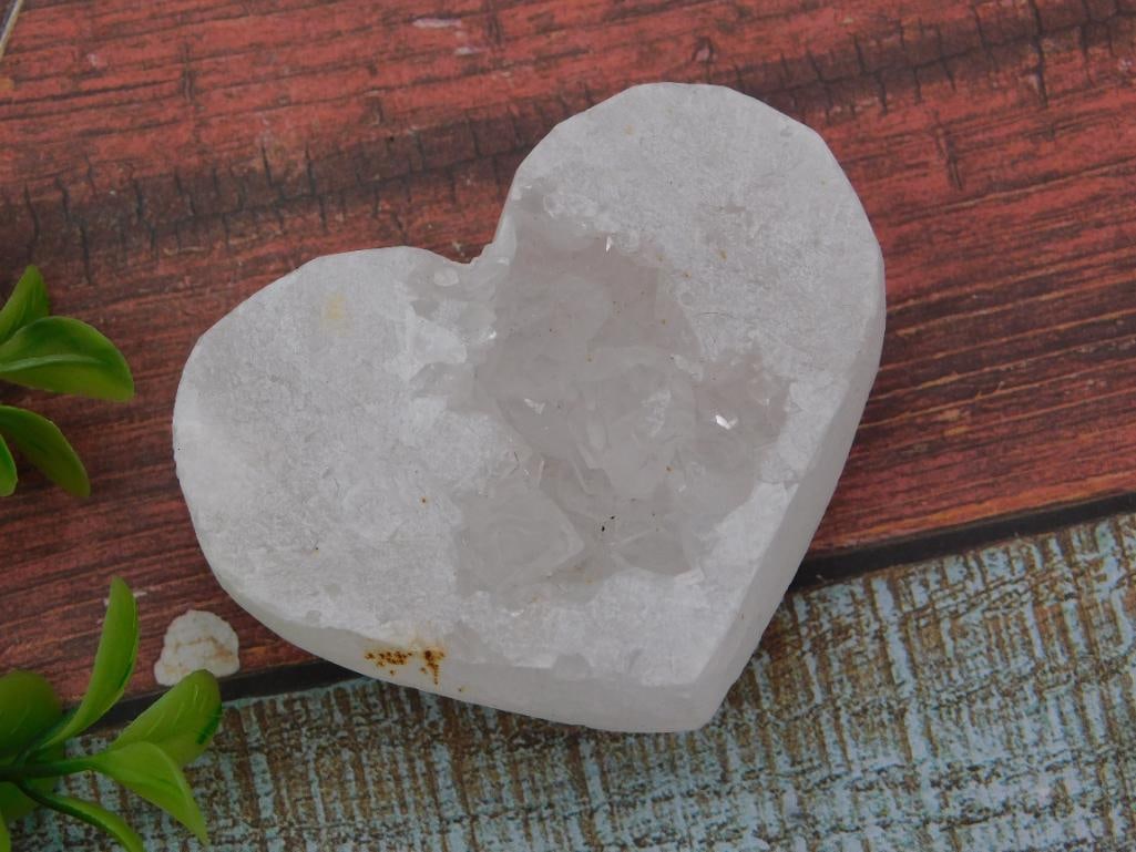 Crystal Quartz Geode Heart-Shaped Carved Rock Specimen: Natural white quartz geode carved into a heart shape, with a druzy crystal-lined cavity visible at the center. Weighs 79 grams per the lot tag; a US quarter is shown alongside for scale, indicating a 