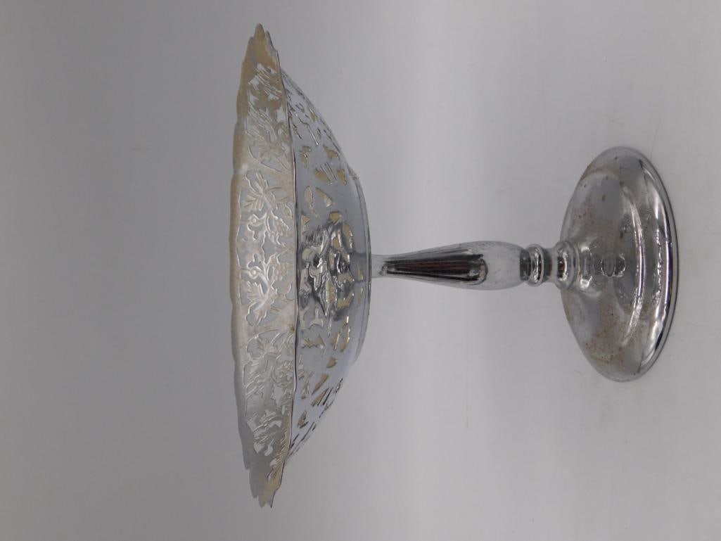 Silver-Plate Pierced Compote Dish with Grape Leaf Design: Footed pedestal compote/tazza dish in silver-plate with an openwork pierced rim featuring a repeating grape and leaf motif. Scalloped edge and single stem base, shows tarnishing and light oxidation co
