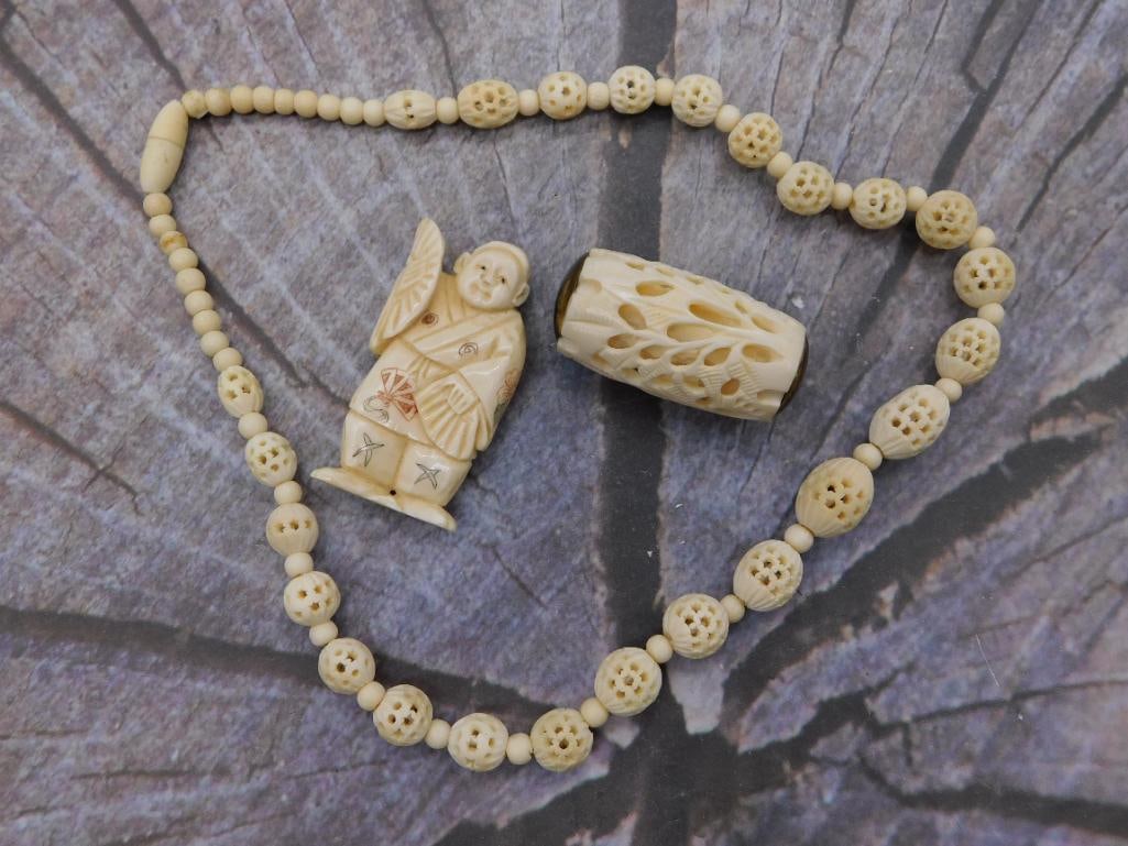 Carved Bone Necklace with Netsuke-Style Figural Bead: Asian carved bone/ivory-style bead necklace featuring reticulated floral round beads alternating with smaller spacer beads, accompanied by a detailed carved figural pendant of a robed man with a fan a
