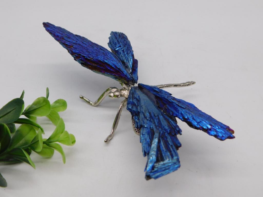 Figurine - Blue Crystal and Silver-Tone Dragonfly Art Piece: A decorative dragonfly figurine with a silver-tone metal body, head, and legs, and four wings crafted from faceted deep-blue crystal or bismuth-style material with iridescent purple highlights. The pi