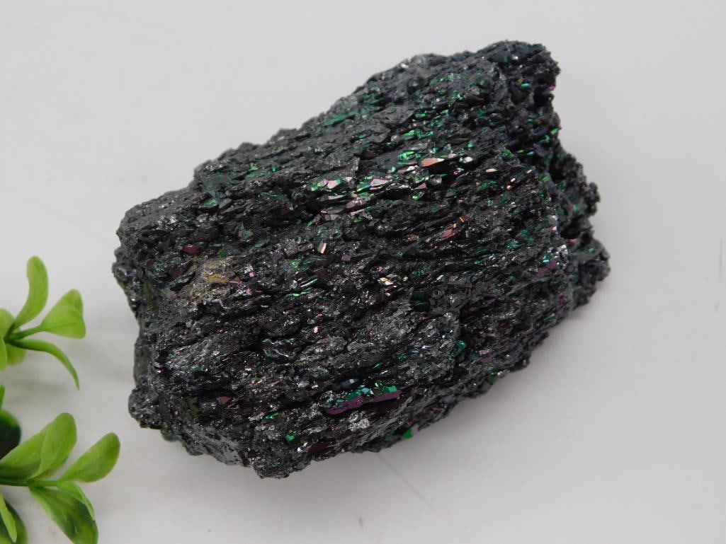 Rock - Carborundum Silicon Carbide Iridescent Mineral Specimen: A natural chunk of iridescent carborundum (silicon carbide) crystal displaying flashes of green, purple, and blue metallic color across its jagged, crystalline surface. Photographed with a quarter for