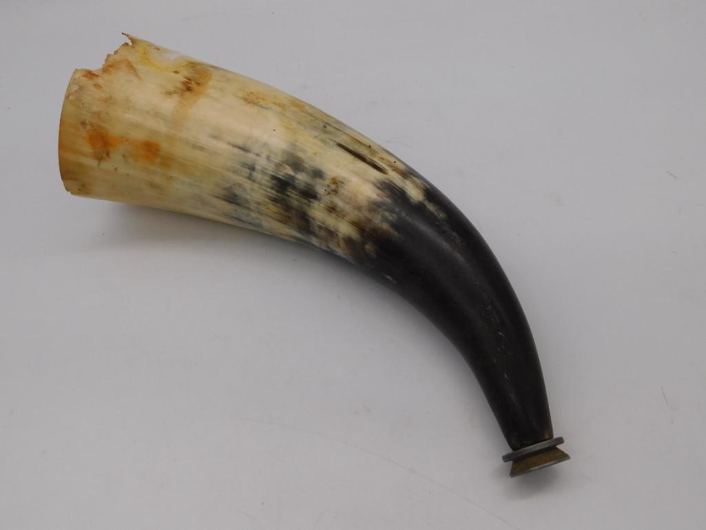 Antique Powder Horn with Brass Spout: A large cow horn powder horn, cream to dark amber/black in color with natural mottling, fitted with a turned brass end cap and spout at the narrow tip. Measures approximately 12 inches long per the