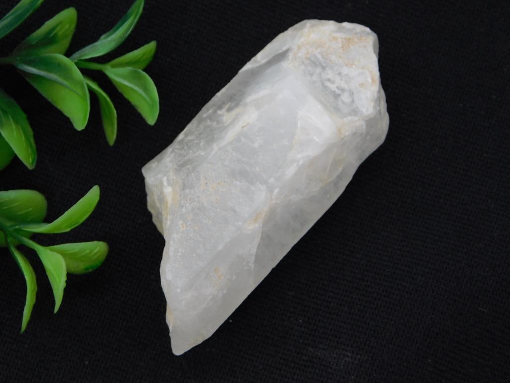 Rock Specimen - Natural Clear Quartz Crystal Point: A natural clear/white quartz crystal point with slight golden-brown mineral inclusions along one edge. Measures roughly 4 inches long, shown with a quarter for scale on a lot card marked "713887, 2026