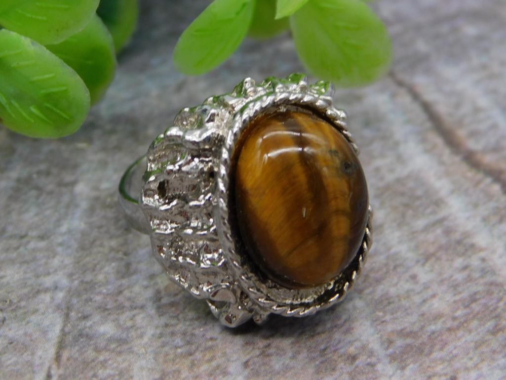 Tiger's Eye Cocktail Ring and Amazonite Crystal Point Lot: A two-item lot comprising a large oval tiger's eye cabochon set in an ornate textured silver-tone cocktail ring, and a polished teal amazonite crystal point. The tiger's eye stone displays classic
