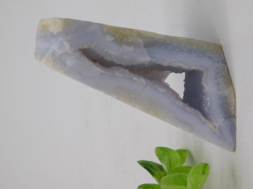 Blue Lace Agate Slab with Natural Crystal-Lined Cavity: A triangular slice of blue lace agate/chalcedony featuring a natural hollow cavity lined with tiny druzy crystal points. Measures approximately 4 inches long, shown against a ruler for scale. Soft