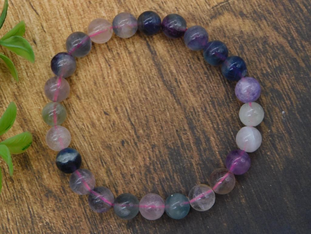 Fluorite Gemstone Beaded Bracelet and Ferrari F40 Diecast Model: A two-item lot including a multicolor rainbow fluorite beaded stretch bracelet with purple, blue, gray, and clear beads shown beside a quarter for scale, and a red Bburago-style 1:18 scale diecast Fer