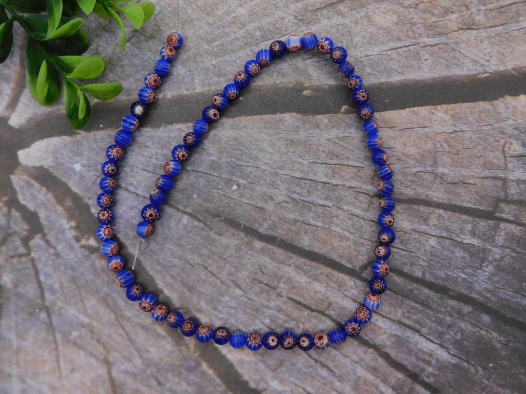 Necklace: Millefiori Glass Bead Necklace with Art Pottery Wall Pocket: Strand of round cobalt blue millefiori (flower-cane) glass beads knotted into a necklace roughly 24-26 inches long, photographed with a ruler for scale. Lot also includes a jade-green glazed art
