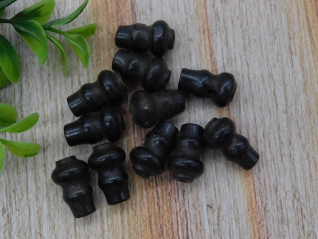 Antique Black Rubber Grommet / Bumper Feet Lot (12 Pieces): A group of twelve black rubber hourglass-shaped grommets or bumper feet, likely furniture or appliance cushion feet. Each piece measures under an inch, shown next to a quarter for scale. Vintage