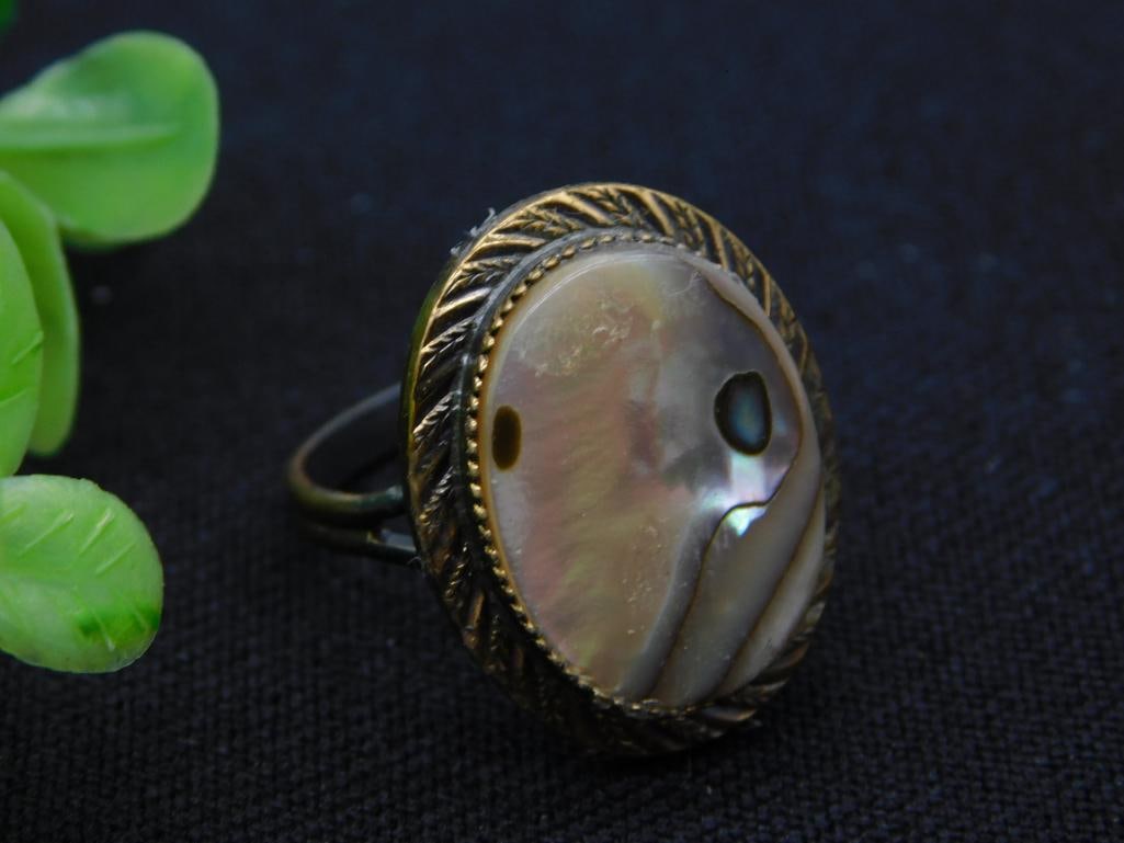 Abalone Shell Adjustable Ring in Gold-Tone Leaf Setting: A vintage costume ring featuring an oval abalone/mother-of-pearl shell cabochon with natural iridescent pink and green shimmer, set in a gold-tone feather/leaf-engraved bezel on an adjustable band.
