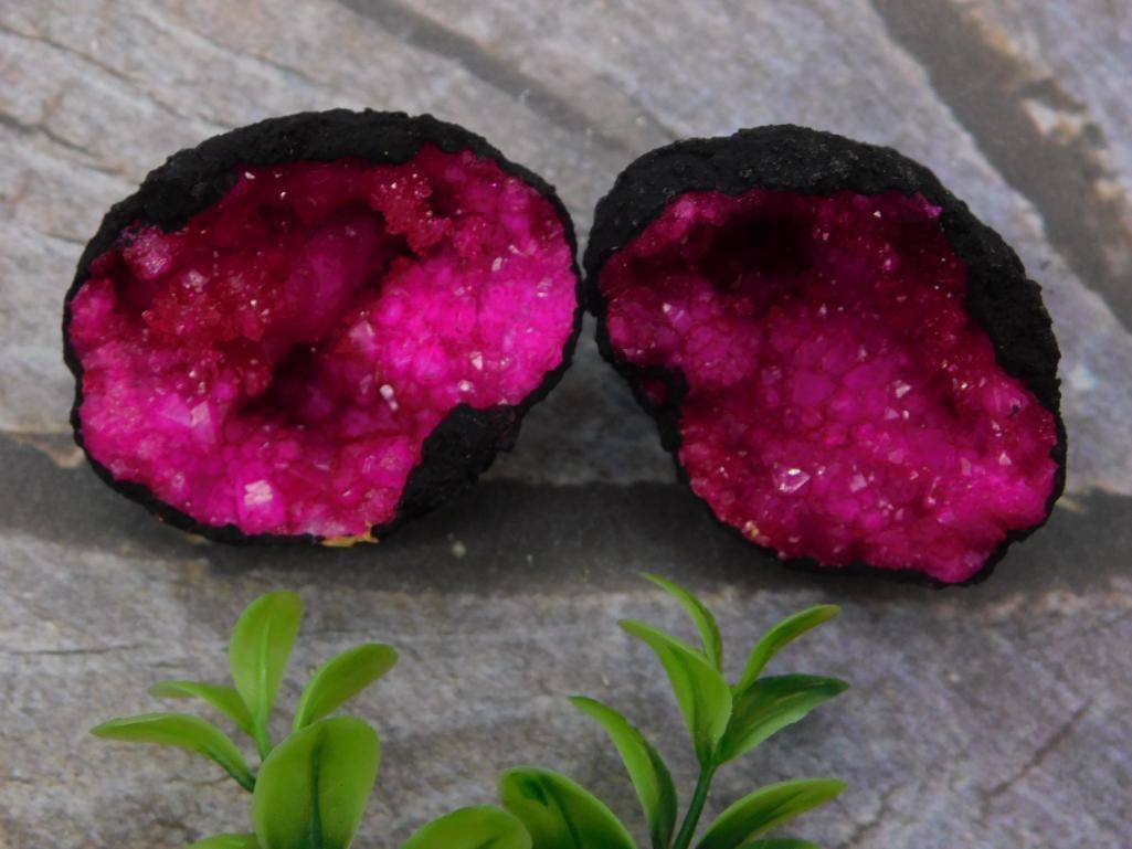 Dyed Pink Agate Geode Halves, 84 Grams: Matching pair of split geode halves with vivid dyed magenta/pink crystal druzy interiors ringed by a dark natural rind, combined weight 84 grams per the lot tag. Sold as a set, likely intended for