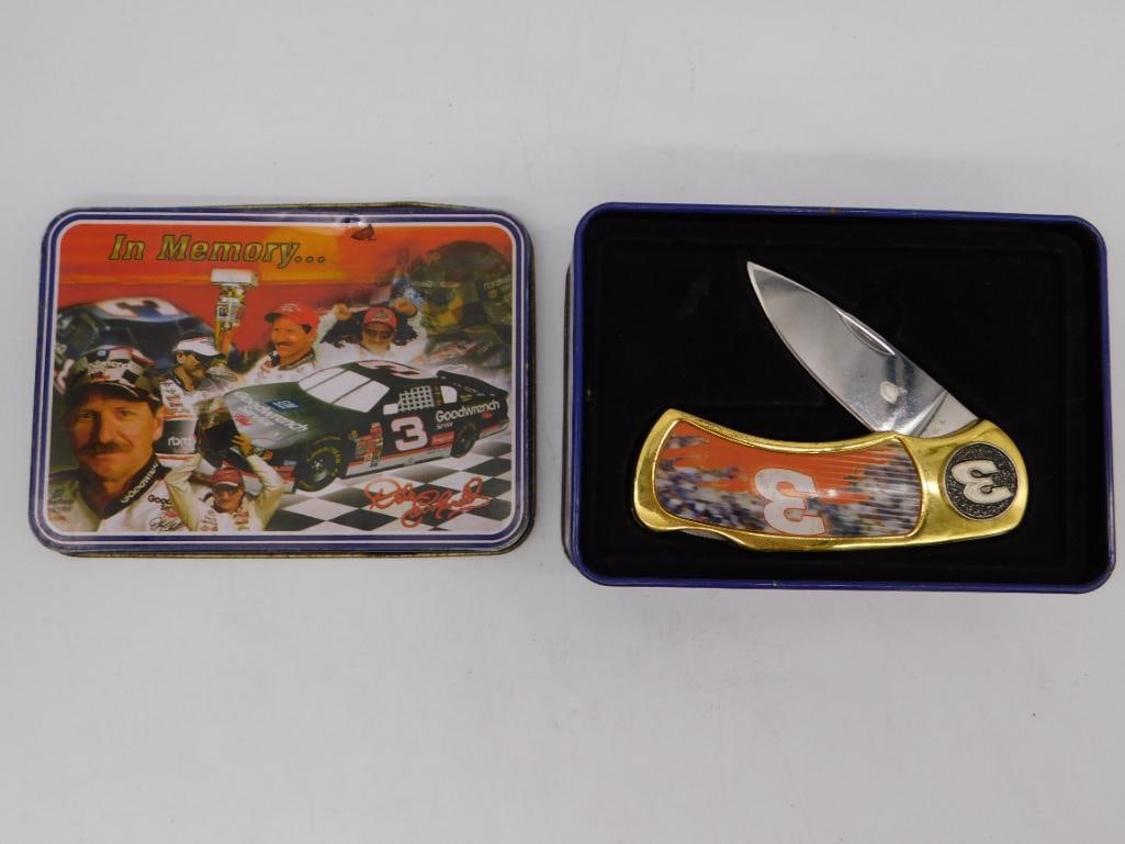 Dale Earnhardt Commemorative Pocket Knife in Collector's Tin: A NASCAR Dale Earnhardt "In Memory..." commemorative folding pocket knife with a gold-tone bolster and graphic scales featuring the #3 Goodwrench racing livery. Housed in a matching hinged