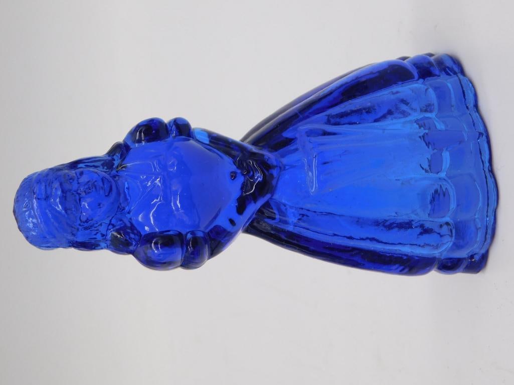 Cobalt Blue Pressed Glass Colonial Lady Figure/Bell: Cobalt blue pressed glass figural piece in the form of a colonial woman in a full ribbed skirt, likely a bell or decorative figurine. Measures approximately 4-5 inches tall as shown against a ruler. V