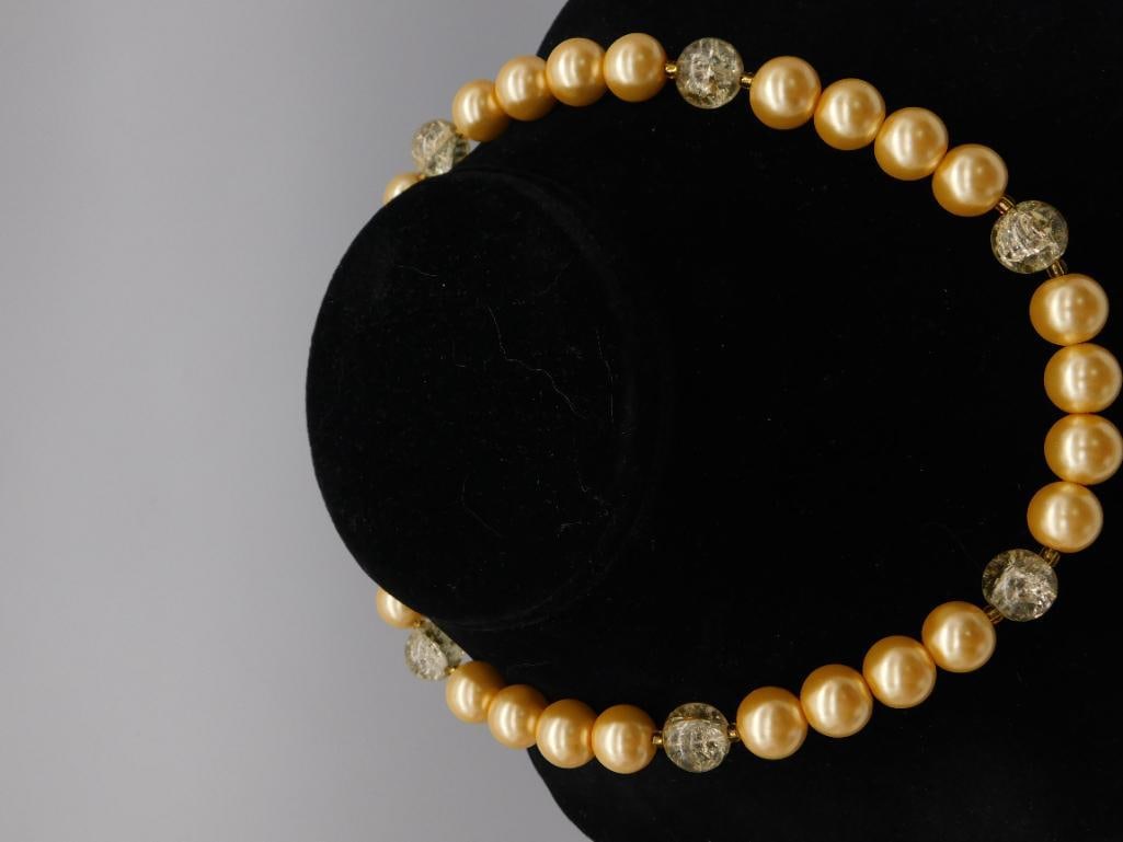 Faux Pearl and Crackle Glass Bead Statement Necklace: Chunky beaded necklace alternating large golden faux pearls with green crackle glass beads on a gold-tone spacer chain, displayed on a black velvet bust. Measures approximately 13-14 inches as shown