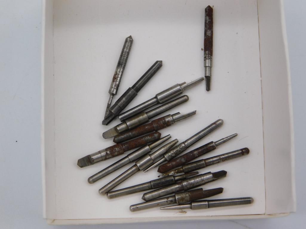 Watchmaker Tool Bit Set - Assorted Gravers and Points: An assortment of roughly eighteen small precision steel tool bits in a cardboard tray, with pointed and beveled ends typical of engraving or watch repair work. A quarter placed beside the tray