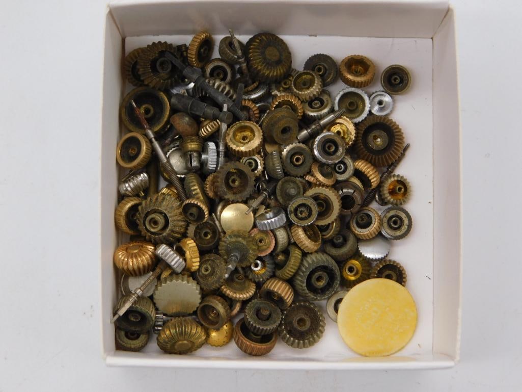 Antique Watchmaker Gear Parts Lot with Yellow Disc: A cardboard box filled with an assortment of small brass and steel gears, fluted knobs, and pinion pieces, along with a yellow plastic disc of unknown function. A quarter is shown for scale. Mixed