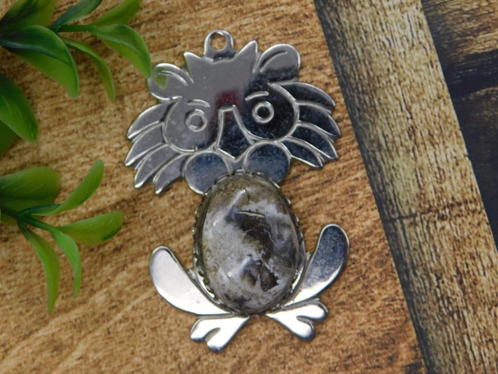 Silver-Tone Owl Pendant with Natural Gemstone Cabochon: A stylized silver-tone owl pendant featuring an oval natural stone cabochon (agate/jasper) set as the owl's body, with detailed etched wings and talons. Measures approximately 2 inches long, shown