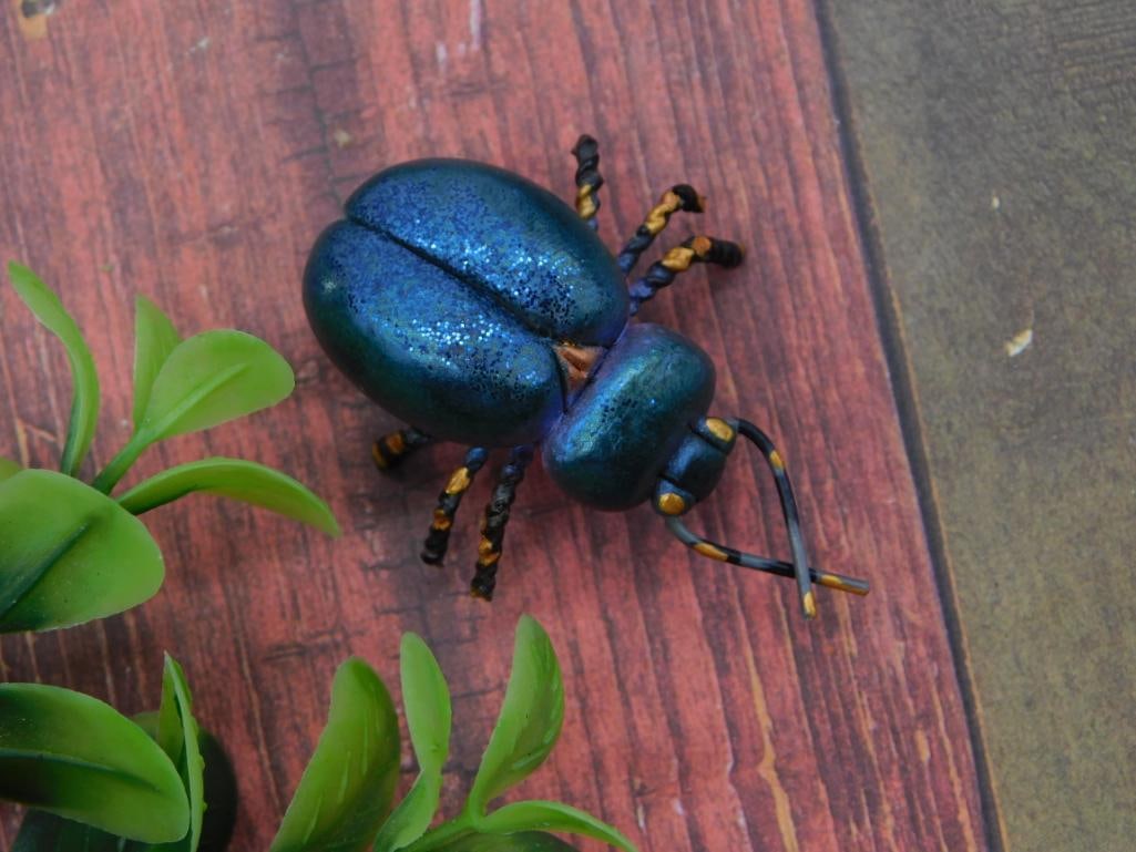 Rhinestone Beetle Brooch Pin, Blue Glitter Enamel: A statement beetle-shaped brooch pin finished in iridescent blue glitter enamel with gold-tone banded legs and antennae, and a secure pin-back clasp. Measures approximately 2 inches long, shown with