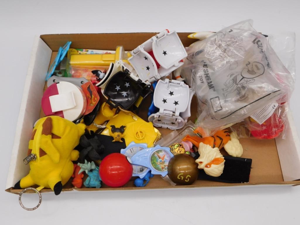 Pokemon Toy Figure & Accessory Box Lot: Mixed box lot of Pokemon collectibles including a plush Pikachu zipper pouch, several small PVC figures, Poke Ball-themed containers with star clasps, a wristwatch, and assorted loose accessories.
