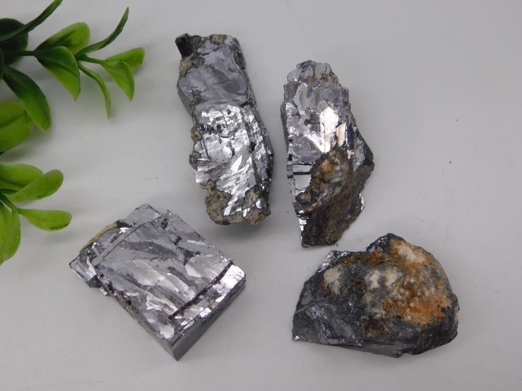 Rock Specimen Galena Mineral Crystal Lot: Lot of four galena mineral specimens with bright metallic silver cubic crystal faces and some included matrix. Weighs approximately 326 grams.