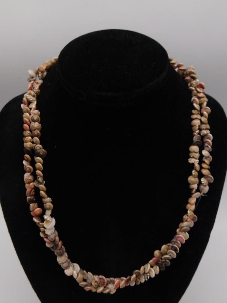 Triple Strand Natural Shell Bead Necklace: Multi-strand necklace made of small polished natural shell beads in tan, brown, pink, and cream tones, approximately 21 inches long.