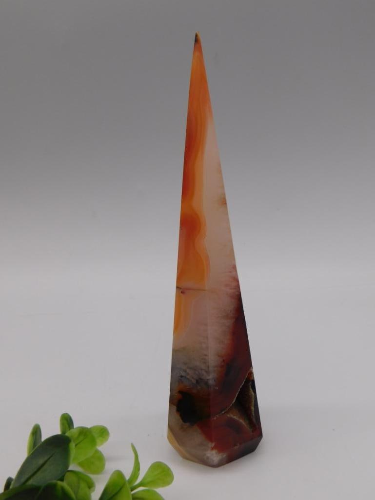 Carved Carnelian Agate Obelisk Tower: Tall polished carnelian agate obelisk/tower carving with banded orange, cream, and dark druzy base, approximately 7 inches tall.
