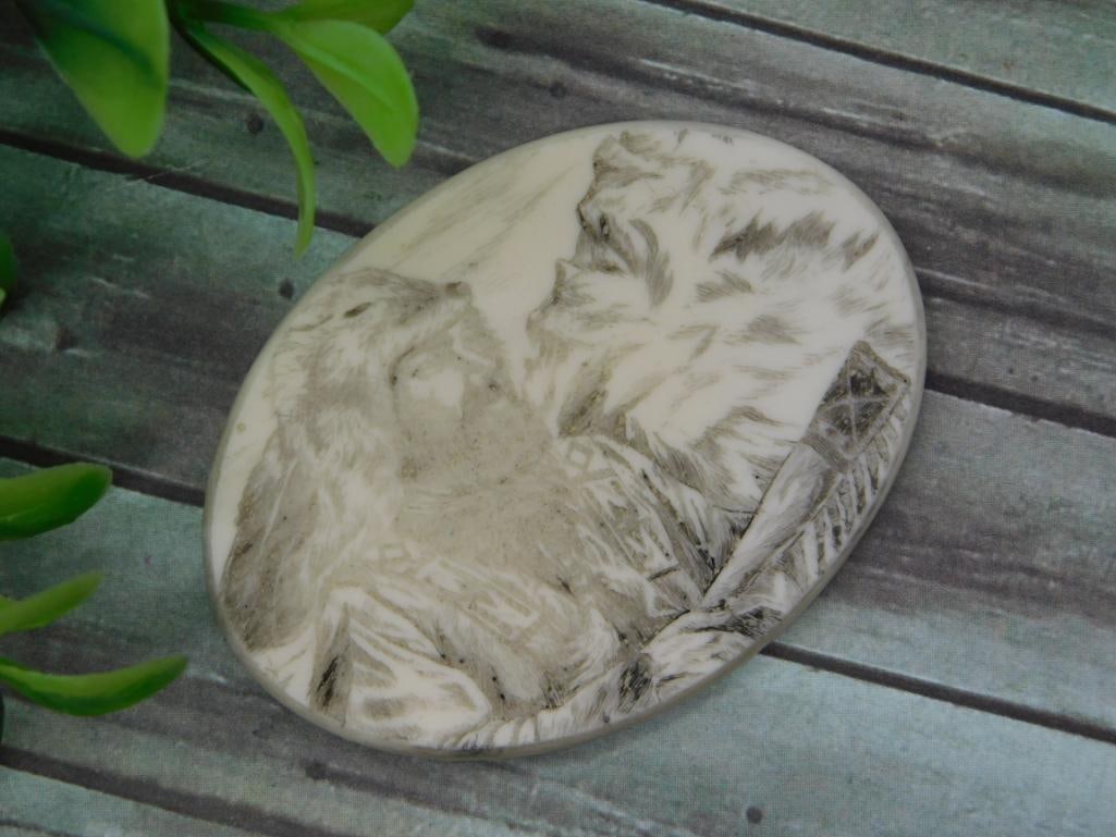 Scrimshaw-Style Carved Oval Plaque: Oval bone/resin plaque with etched scrimshaw-style artwork depicting a Native American figure and mountain scene.