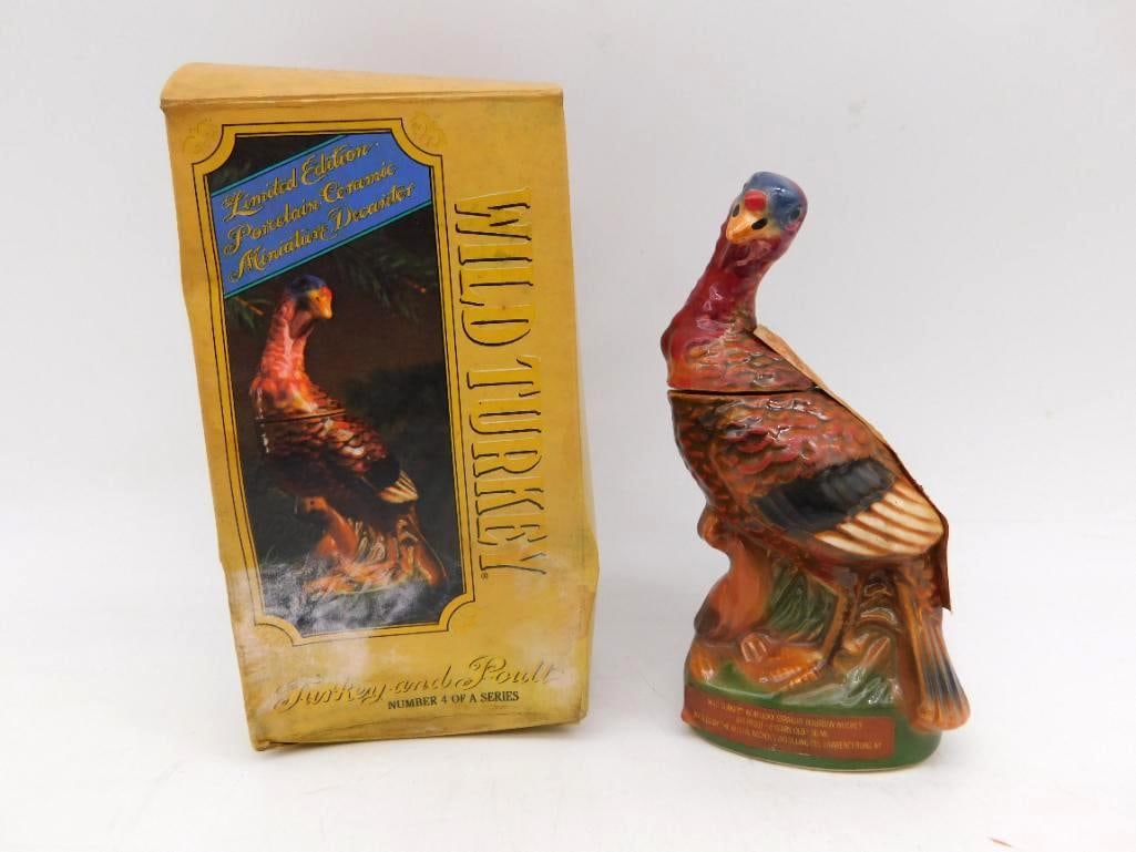 Wild Turkey Turkey and Poult Miniature: A Wild Turkey miniature decanter modeled as a turkey and her poult, the hen standing among grasses with the chick tucked at her feet. The plumage is hand painted with an admirable eye for the bird's