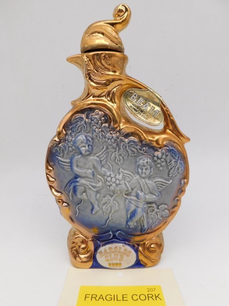 Jim Beam Harolds Club Reno Cherub and: A fetching Jim Beam Regal China decanter in gold and cobalt, the face molded with cherubs at play among grapevines and the reverse worked in a quilted diamond ground. The gilding is bright and the mod