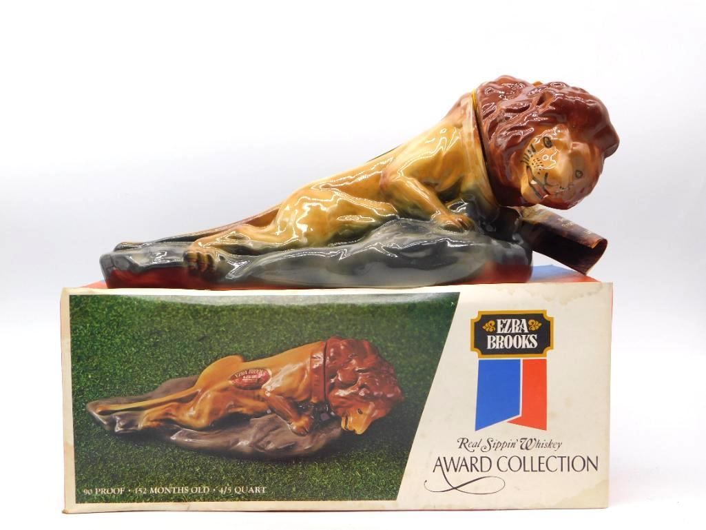 Ezra Brooks Award Collection Reclining: A stout Ezra Brooks bottle modeled as a lion at rest upon a shelf of gray rock, the great mane worked in deep russet and the coat glazed a warm honey. The sculptor gave him a sober, unhurried air, and