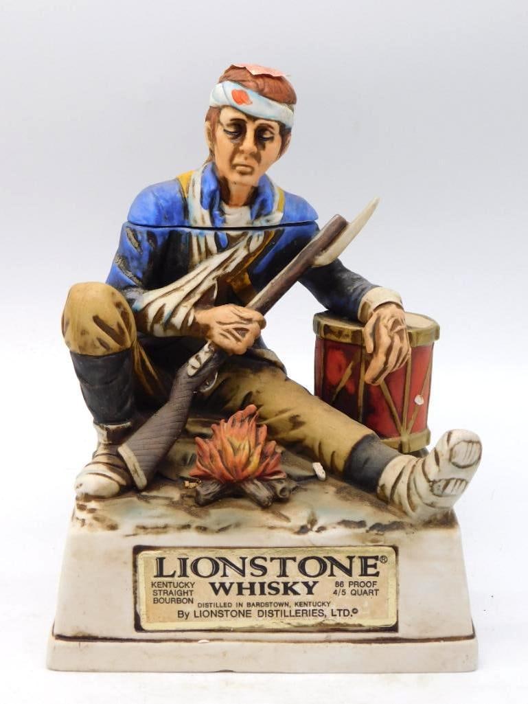 Lionstone Bicentennial Series Winter at: A Lionstone decanter from the Bicentennial Series, modeled as a Continental soldier seated at his campfire with musket across his knee, a drum at his elbow, and rags bound about his feet. The