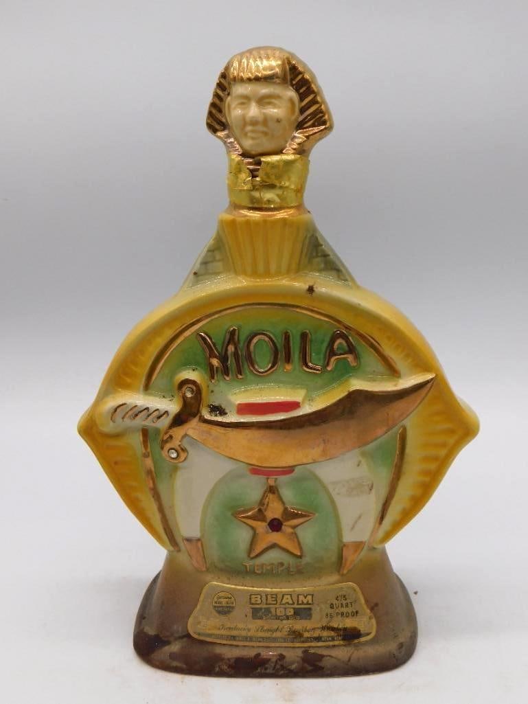 Jim Beam Moila Shrine and Ezra Brooks: Two ceramic decanters offered together. The first is a Jim Beam Moila Shrine Temple bourbon decanter in gold and green. The second is an Ezra Brooks American Legion medallion decanter in blue and