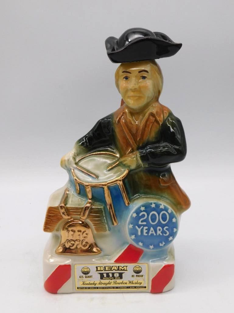 Jim Beam Mint 400 Desert Race Pyramid: Two Jim Beam decanters offered together. The first is a gold-glazed pyramid for the 1975 Mint 400, Del Webb's Desert Race, with off-road racing scenes worked in relief. The second is a Bicentennial