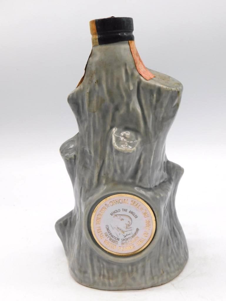McCormick Behold the Angler Fishing Hall: A McCormick decanter sculpted as a weathered tree stump, its medallion reading Behold the Angler, Official Seal of the National Fresh Water Fishing Hall of Fame, Conservation, Hayward, Wisconsin.