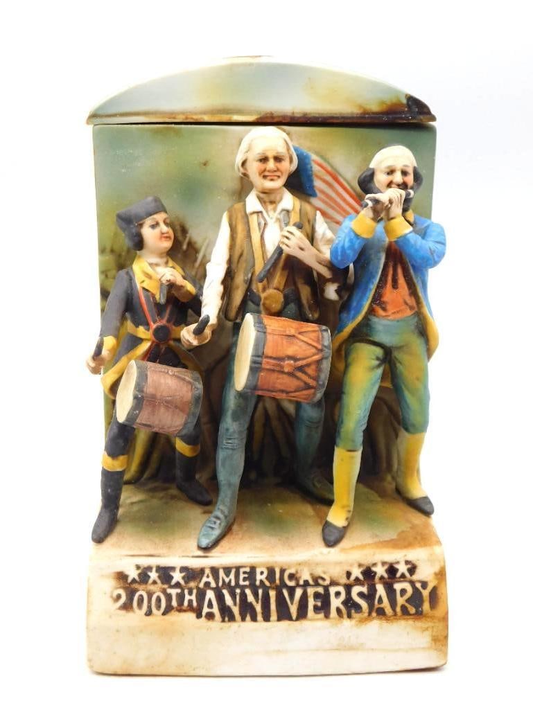 McCormick America's 200th Anniv.: A McCormick decanter cast with three marchers of the Revolution, two at the drums and one at the fife, stepping out beneath a tattered flag. The relief is deep and the painting earnest, the blue and