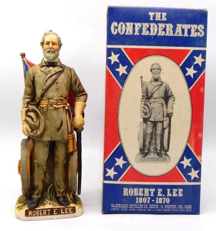 McCormick The Confederates Robert E. Lee: A dignified McCormick decanter from The Confederates series, modeled as Robert E. Lee standing hat in hand before a furled battle flag. The gray uniform and white beard are rendered with a shrewd eye,