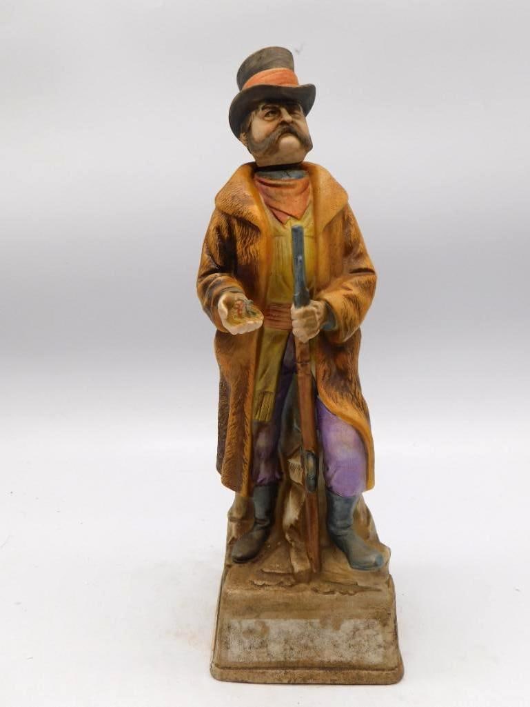 Lot of 2 Old West Series Frontiersman: Two ceramic whiskey decanters from an Old West series: a "Frontiersman, 1790-1843" in fringed buckskin with its original tax stamp intact, and a companion "Renegade Trader" — so marked on the