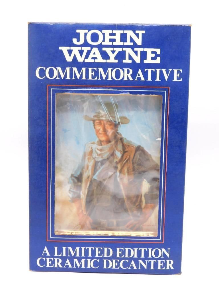 John Wayne Comm. Ltd Ed Ceramic Decanter: A John Wayne commemorative ceramic decanter still shut up in its original blue carton, which carries a tag stating the box has been sealed and never opened. The front window shows the Everett Raymond