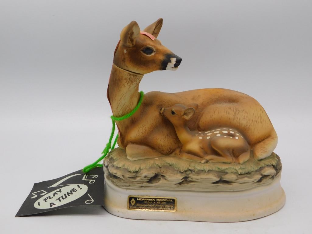 Hoffman Orig Doe and Fawn Music Box: A tender Hoffman Original decanter modeled as a doe at rest with her spotted fawn nestled against her flank, the pair set upon a stone and grass base. The bisque coat is airbrushed with an earnest