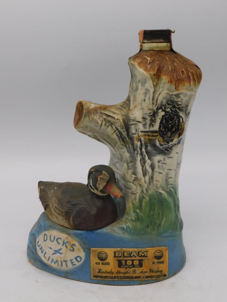 Ceramic Duck Decanter on Tree Stump Base: A hand-painted ceramic decanter modeled as a waterfowl perched on a tree-stump base, finished in naturalistic mottled brown and green tones. No maker's mark is visible in the photos provided, though