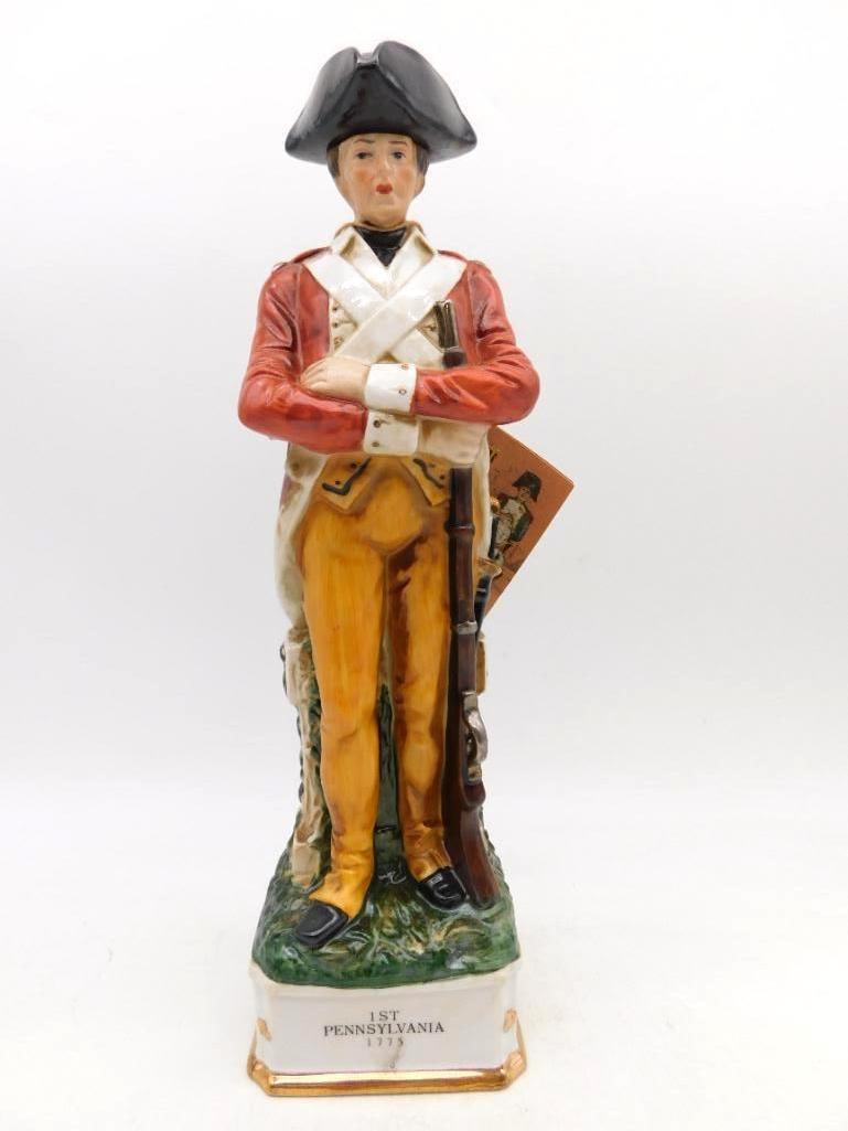 Grenadier 1st Pennsylvania 1775: A stately Grenadier Spirits Co. decanter modeled as a soldier of the 1st Pennsylvania, 1775, standing at ease in scarlet coat and buff breeches with musket at his side. The hand painting is uncommonly
