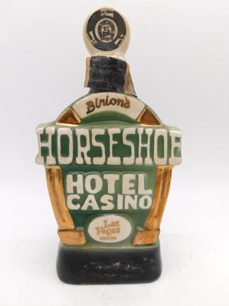 Binion's Horseshoe Hotel Casino Las: A decanter cast as the marquee of Binion's Horseshoe Hotel Casino at Las Vegas, the stopper modeled as a hundred-dollar gaming chip. The reverse carries the house's famous horseshoe of cash in gilt an